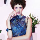Kobaltblaues Top mit bronzefarbenem Blumendruck, Fransentasche und Armreif mit
 Schmucksteinen, alles von Giorgio Armani
