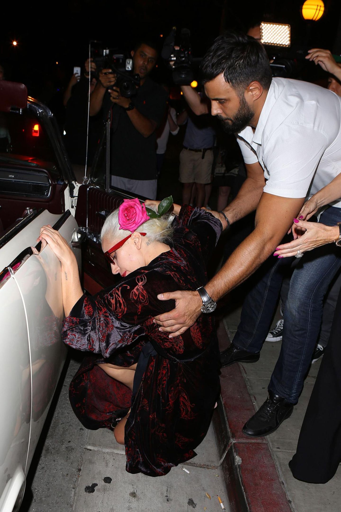 Lady Gaga will in West Hollywood eigentlich ganz cool ins Cabrio einsteigen. Allerdings hat sie diese Rechnung ohne ihr langes Kleid und die hohen Schuhe gemacht. Ein junge Mann eilt der Sängerin allerdings sofort zu Hilfe.