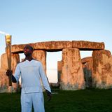 Der einstige US-amerikanische Spitzenathlet Michael Johnson übernimmt die olympische Fackel vor dem Weltkulturerbe Stonehenge.