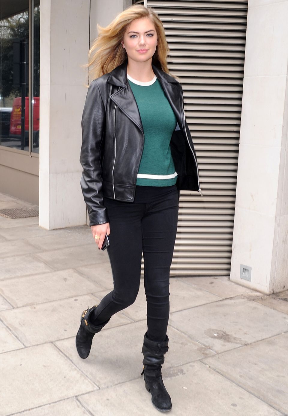 Kate Uptons Casual-Look wirkt durch Lederjacke und Boots zu ihrem grünen Sweater besonders cool.