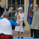 9. Oktober 2013: Queen Elizabeth und Prinz Philip winken vor dem Buckingham Palast in London dem ersten Stabträger der "Commonwealth Games", die 2014 im schottischen Glasgow stattfinden.