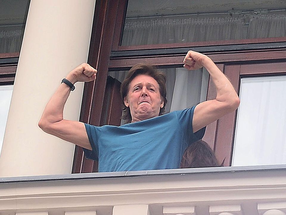 22. Juni 2013: Paul McCartney lässt auf dem Balkon eines Hotels in Warschau die Muskeln spielen, um eine Fans zu beeindrucken.