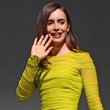 In einem neongelben Kleid von Versace leuchtet Lily Collins sogar auf einer dunklen Bühne.