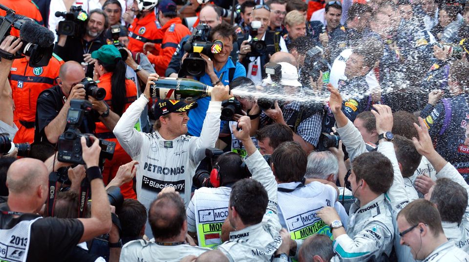 Der Sieger Nico Rosberg verteilt den Champagner in der Menge.