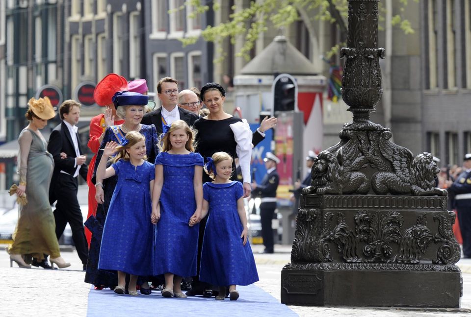 Auf dem Weg in die Nieuwe Kerk zur Huldigung: Die Prinzessinen Amalia, Alexia und Ariane tragen Kleider in Nassau-Blau. Hinter ihnen kommen Prinzessin Beatrix, Prinz Constantijn, Prinzessin Laurentien und Prinzessin Mabel.