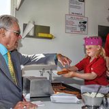 Prinz Henrik bekommt an einem typisch dänischen Imbisswagen eine "risted pølser", eine Bratwurst, serviert. Wie man sieht, hätte die junge Wirtin ihrem royalen Gast auch ein Hot Dog zubereiten können.