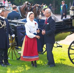 Königin Silvia, Prinz Carl Philip und König Carl Gustaf kommen mit der Kutsche zum Festplatz.