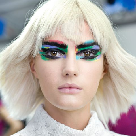 Ungewohnt farbenfroh und rockig schickte Chanel seine Models auf den Laufsteg. Das extravagante Augen-Make-up wird durch platinblonde Perücken noch betont.