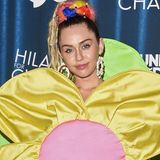 Was wäre ein Auftritt von Miley Cyrus ohne ein sonderbares Outfit? Im zweifelhaften Blumenkleid und mit gigantischen Ohrringen und Dreadlocks besucht die Sängerin ein Charity-Event.