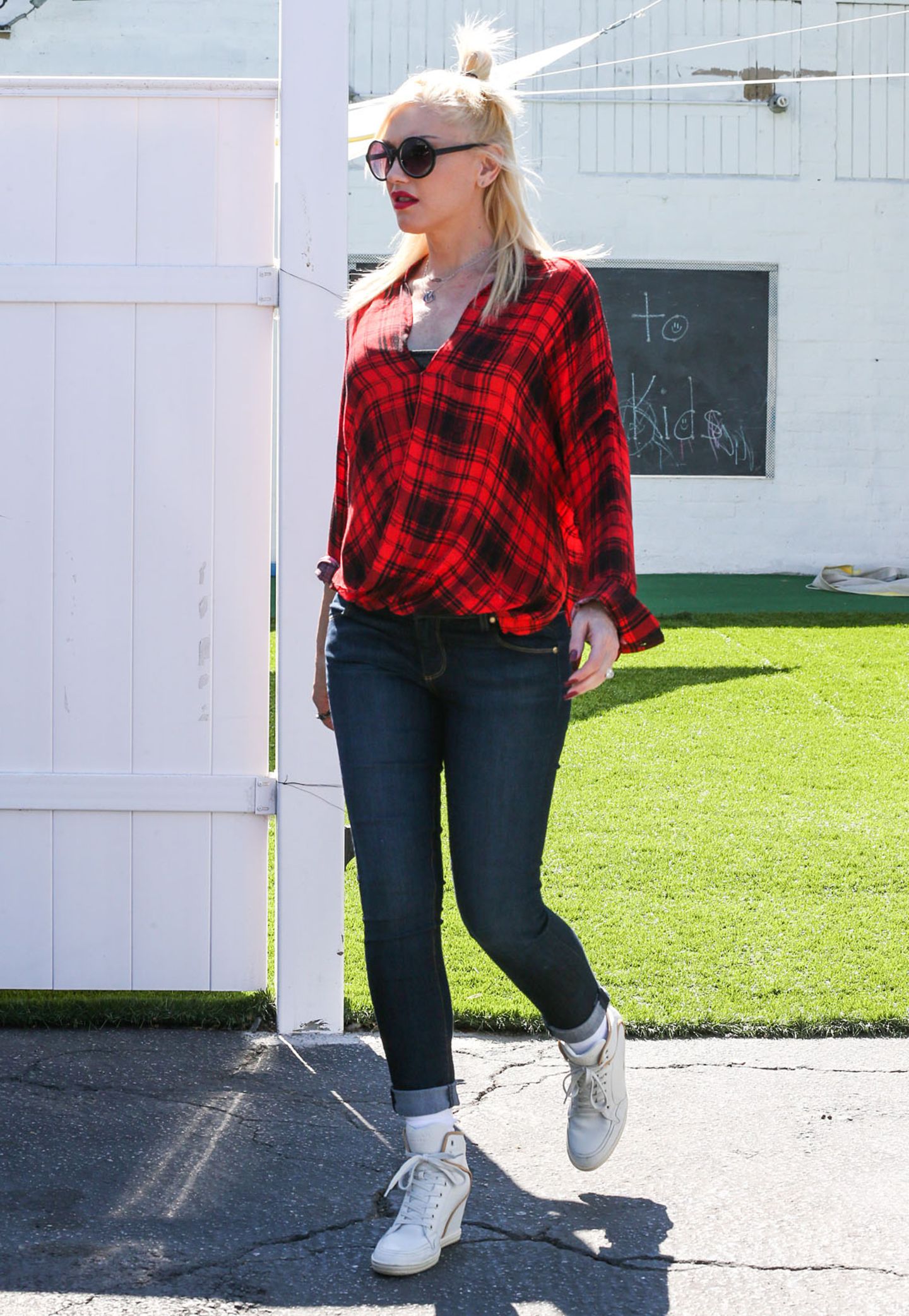 Das rote Karohemd im Wickel-Look lässt den Gwens Bauch nur erahnen. Jeans dazu und weiße Sneaker, fertig ist das sportliche Alltagsoutfit.