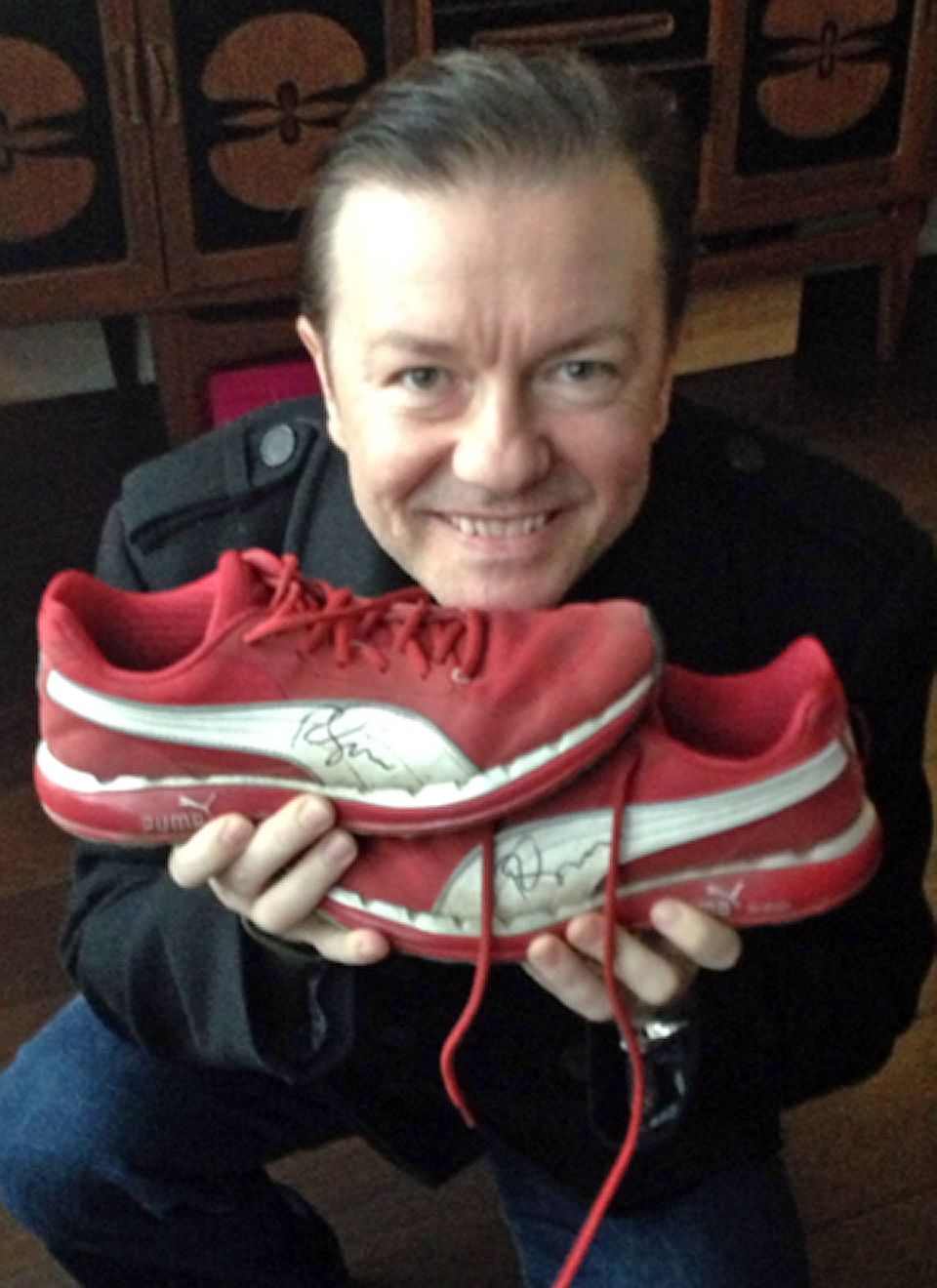 Comedian Ricky Gervais spendet für "Small Steps" seine roten Puma-Turnschuhe.