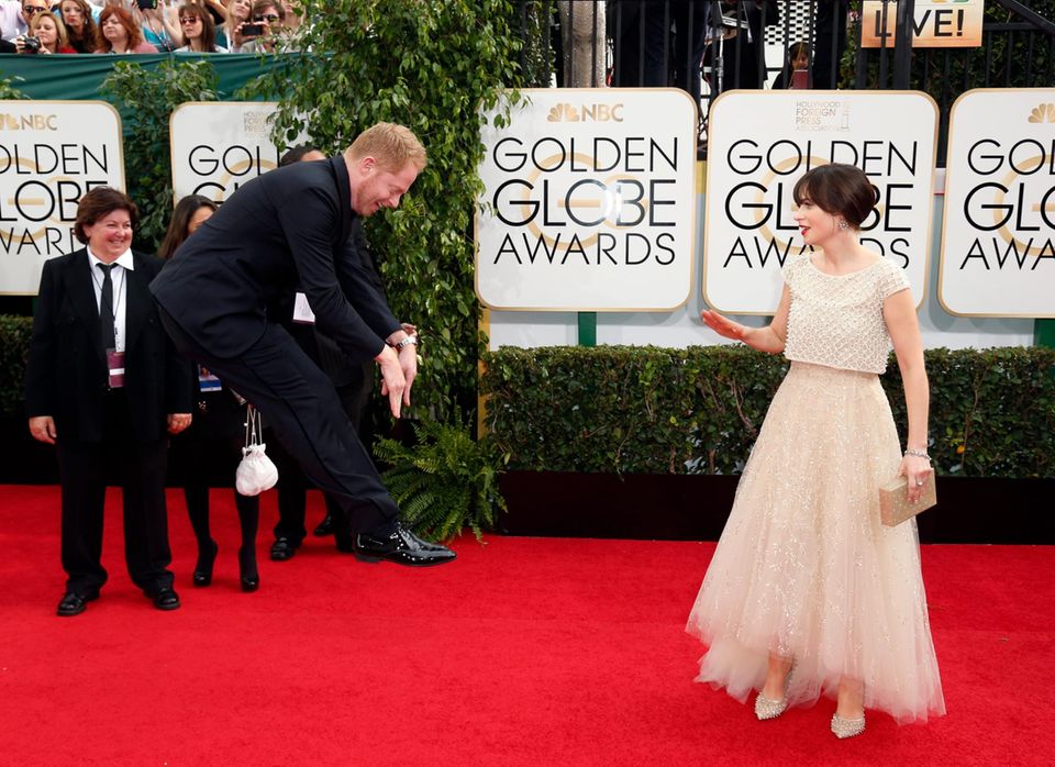 Zooey Deschanel und Jesse Tyler Ferguson machen Späßchen auf dem roten Teppich.
