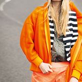 Die Oversize-Kapuzenjacke in Netzoptik, von Adidas by Stella McCartney, lässt den schwarz-weißen Streifenblazer, von Jake's über www.fashionid.de, durchschimmern. Der olivgrüne Nylonblouson mit Leomuster von Joop, ist so dünn, dass man ihn sogar drunter anziehen kann. Sport-Shorts in Neon-Orange, von H&M