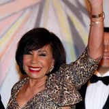 Sängerin Shirley Bassey winkt freudig, als sie ankommt.