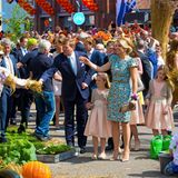 Gemeinsam mit ihren drei Töchtern schauen sich König Willem-Alexander und Königin Máxima - gefolgt von anderen Mitglieder der Familie - Blumen und Pflanzen an. Bewacht werden diese von einer Art lebendigen Vogelscheuche, die dem König sogar die Stroh gefüllte Hand reicht.