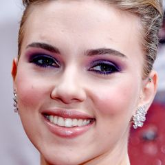 Scarlett Johansson trägt ihre Haare streng nach hinten, damit der Blick auf ihre fantastisch geschminkten Augen frei ist.