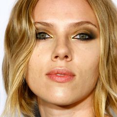 Für ihr Make-up à la Femme Fatale schminkt Scarlett Johansson ihre Augen besonders verrucht. Zu den Smokey Eyes in Schwarz und Gold spitzt sie zusätzlich ihre vollen Lippen, um den verführerischen Look zu unterstreichen.