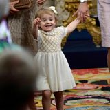 Prinzessin Estelle scheint, als sie an der Hand von Prinzessin Victoria die Kirche verlässt, etwas Spannendes entdeckt zu haben.