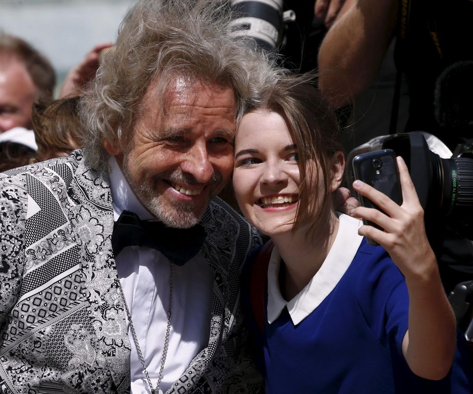 Dieser junge Fan schnappt sich Thomas Gottschalk für ein Selfie. Der Star ist auf dem Weg ins Bayreuther Opernhaus.