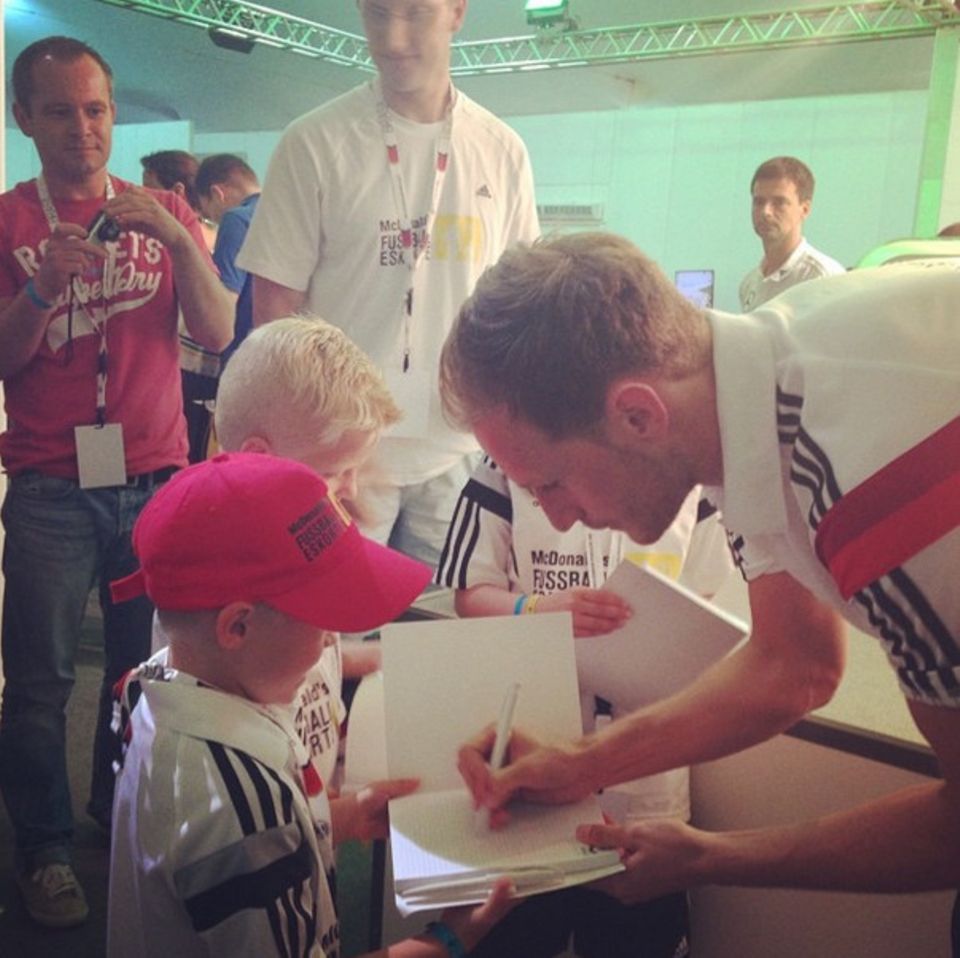 Benedikt Höwedes gibt seinen jüngsten Fans Autogramme.