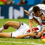 Schrecksekunde: Klose hält Müllers Kopf, als dieser nach seinem Zusammenstoß mit einer blutenden Platzwunde am Boden liegt.