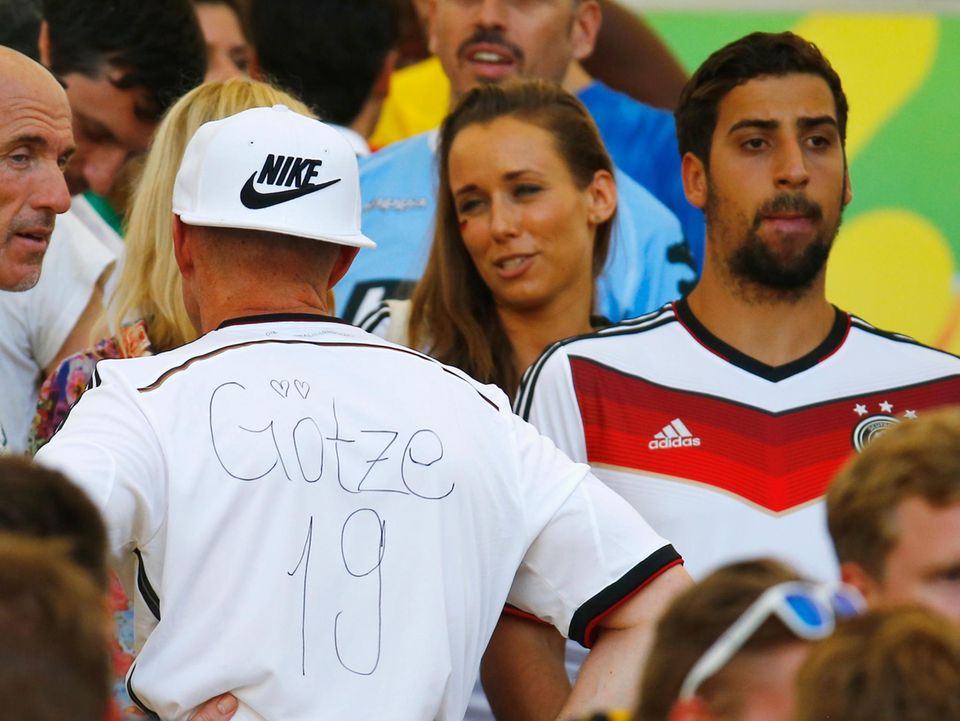Mario Götzes Vater Jürgen zeigt sein selbst beschriftetes Trikot. Neben ihm steht Rani, der Bruder von Sami Khedira.