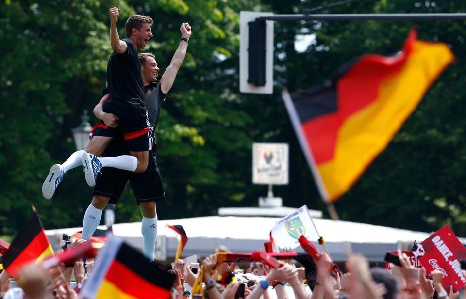 Manuel Neuer und Thomas Müller scheinen vor lauter Jubel auf der Fanmeile fast zu schweben. Manuel Neuer und Thomas Müller scheinen vor lauter Jubel auf der Fanmeile fast zu schweben.