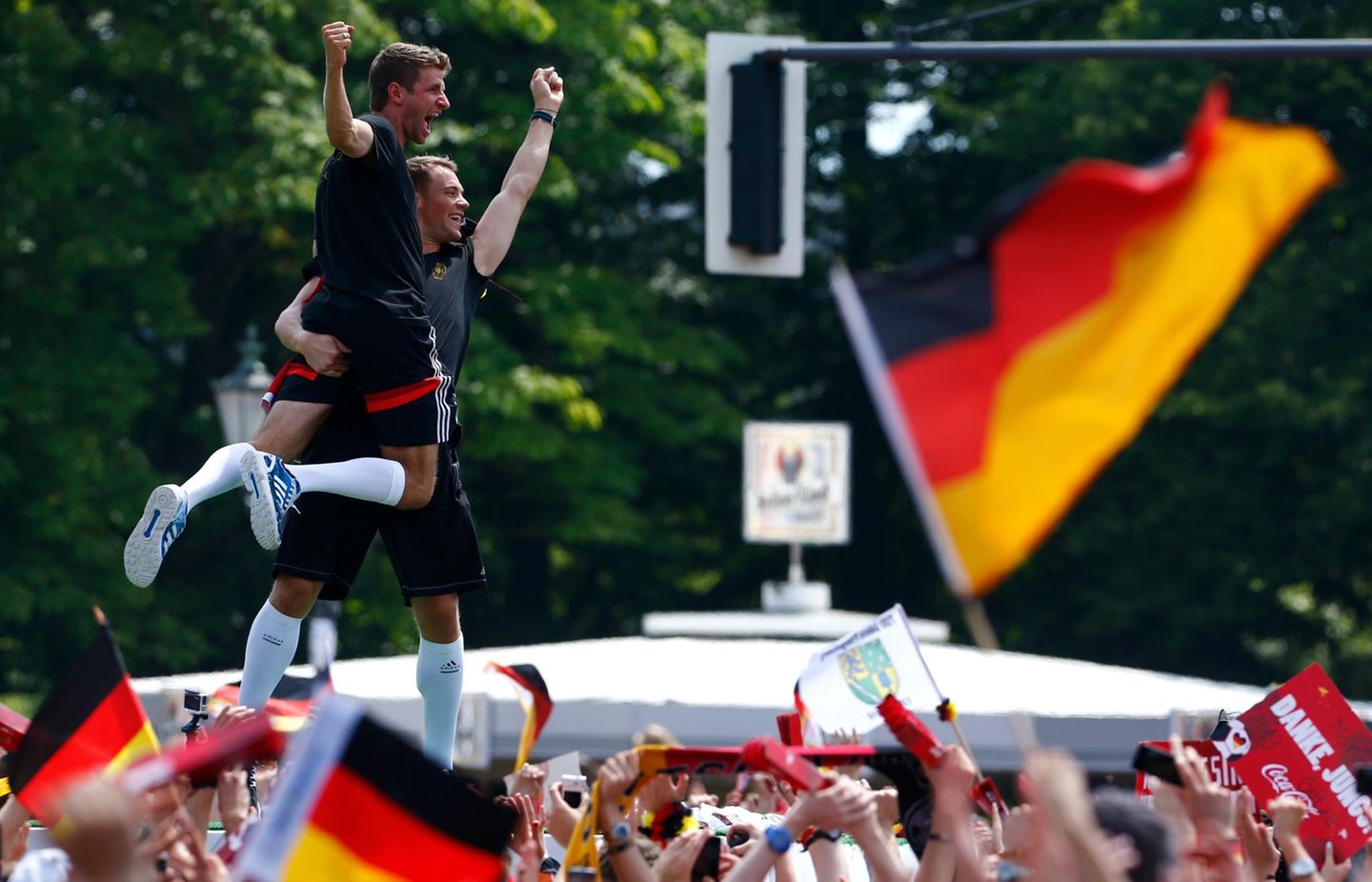 Manuel Neuer und Thomas Müller scheinen vor lauter Jubel auf der Fanmeile fast zu schweben.