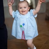 Das hellblau gestreifte Kleid mit Ballon-Applikation, das Prinzessin Estelle an ihrem ersten Geburtstag trug, hat ihre Mutter Victoria im gleichen Alter auch schon getragen.