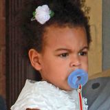 Passend zum Kleid haben Mama Beyoncé und Papa Jay-Z Blue Ivys Haar mit einer weißen Blume geschmückt. Besonders erfreut scheint die Kleine darüber aber nicht zu sein.