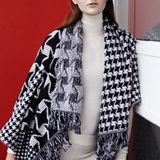 Der Hit zum Einhüllen: schwarz-weißer Oversize-Poncho mit Fransen und unterschiedlich großem Hahnentritt-Jacquard. Von Stella McCartney. Feiner Turtleneck-Pulli von Steffen Schraut. Strick-Leggings von Barbara Bui. Ringe von Vitamin D Jewellery