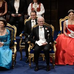 Königin Silvia, König Carl Gustaf und Kronprinzessin Victoria sitzen auf der Bühne in der ersten Reihe. Hinter ihnen Prinz Daniel.