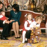 1982  Prinzessin Madeleine, die im Juni geboren wurde, feiert das erste Weihnachtsfest. Ihre beiden älteren Geschwister Victoria und Carl Philip sind ebenso weihnachtlich angezogen wie die Kleine, spielen aber schon auf einem Schaukelpferd.