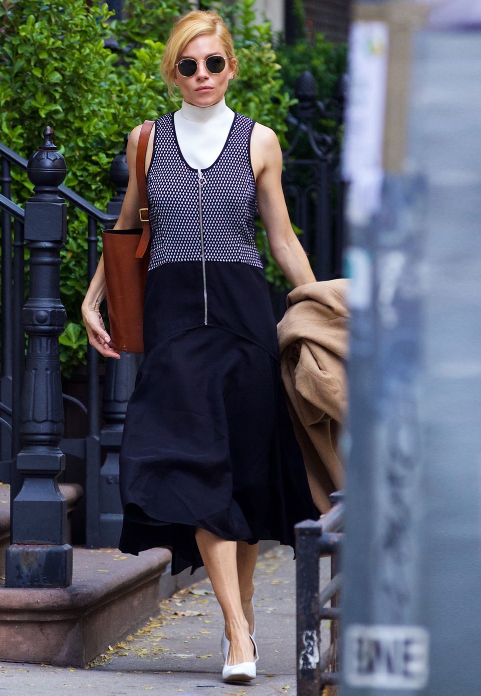 Eine perfekte Mischung aus avantgardistisch und klassisch: Sienna Miller hetzt im futuristischen Kleid, mit Ray-Ban-Sonnenbrille und abgetragenem Ledershopper durch New York.