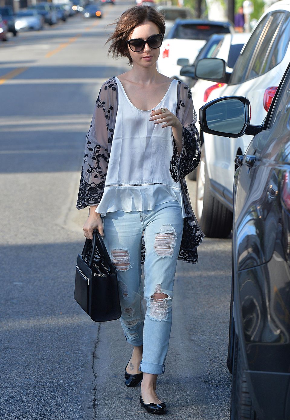 Zerfetzte Boyfriend-Jeans, weißes Hänger-Top und ein angesagter Kimono reichen Lily Collins vollkommen, um einen stylischen Alltagslook zu kreieren.