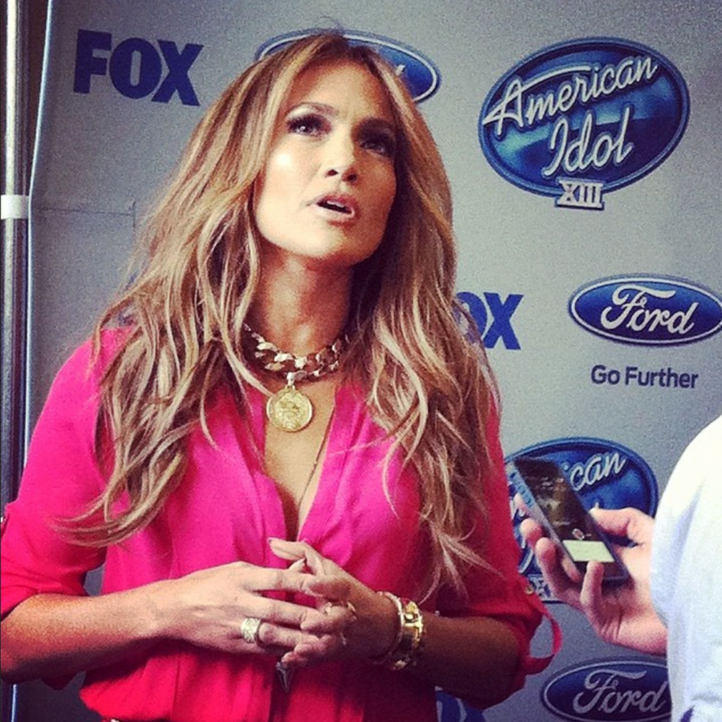 Einer rassigen Latina wie J.Lo steht knalliges Pink besonders gut. Dazu kombiniert sie goldenen Schmuck und sanft gewelltes Haar.