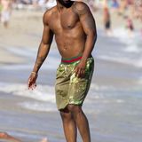 Jason Derulo präsentiert stahlhart seinen Body mit Tattoos und wählt als Kontrast einen Blütenshort in milden Grüntönen.