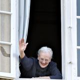 Königin Margrethe, nun offiziell 75 Jahre alt, grüßt aus einem Fenster von Schloss Fredensborg ihre royalen Gäste, die sich darunter versammelt haben.