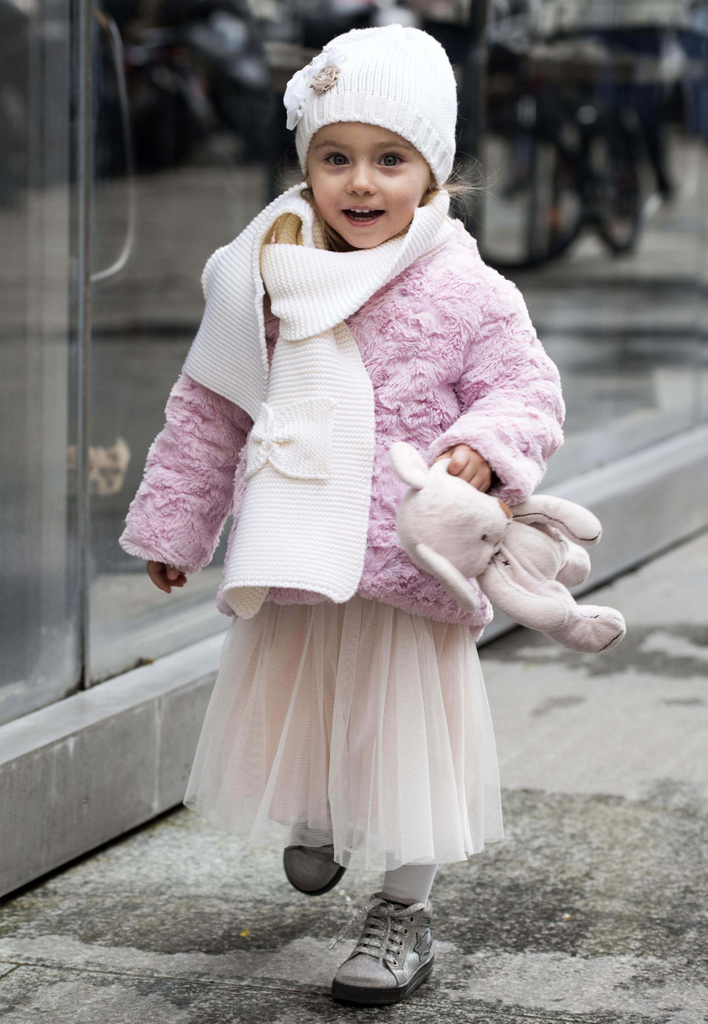 Wie eine kleine Prinzessin spaziert Sole Trussardi im rosafarbenen Mädchentraum-Outfit mit Teddy-Jacke und Tutu durch den grauen Matsch.