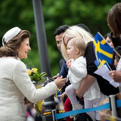 Königin Silvia nimmt sich die Zeit, einem kleinen Mädchen die Hand zu schütteln. Gemeinsam mit König Carl Gustaf (ganz links) ist sie zu den Nationaltagsfeierlichkeiten in Örebro.