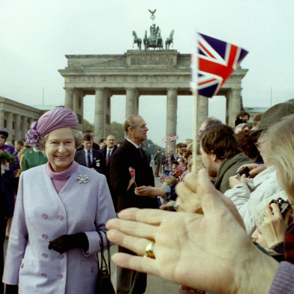 1992  Fahneschwenken für das vereintigte Königreich: Die Queen und Prinz Philp begrüßen am Brandenburger Tor die Menschen.