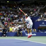 Roger Federer steht gegen John isner auf dem Platz.