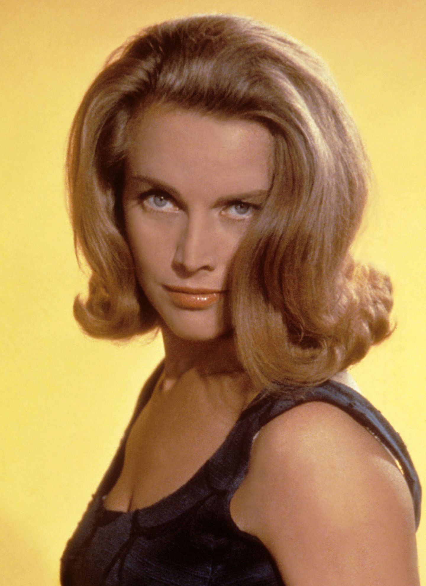 Honor Blackman, die das Bond-Girl "Pussy Galore" in Goldfinger (1964) spielte, unterstrich ihren verführerischen Blick mit voluminösem Sixties-Styling.