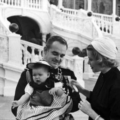 Die kleine Prinzessin Caroline trägt die Nationaltracht, scheint aber - trotz des feierlichen Anlasses - nicht gerade begeistert. Ihre Eltern Fürst Rainier und Fürstin Gracia Patricia kümmern sich liebevoll um ihre 1957 geborene Tochter.