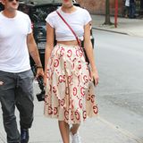 Stylischer Stil-Mix: Supermodel Karlie Kloss hat ihr weißes Shirt lässig nach oben geknotet. Durch die Kombination mit ihren weißen Sneakern wird der der Gesamtlook noch lässiger.