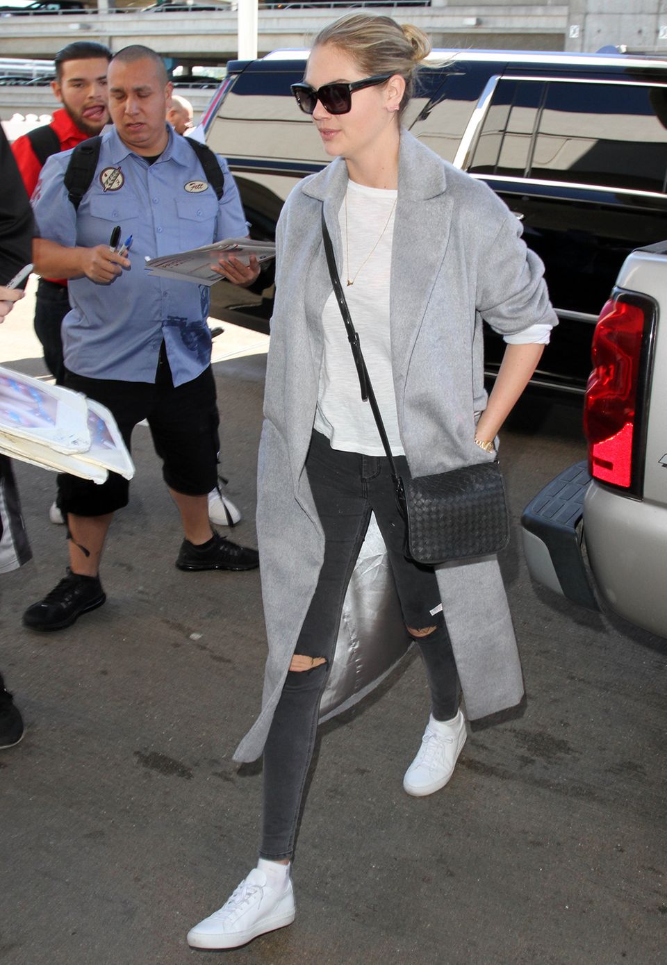 Supermodel Kate Upton hat den lässigen Reise-Style perfektioniert und trägt zu Skinny-Jeans, Shirt und Sneakern einen grauen, überlangen Mantel.