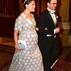 Silberglanz am Kleid und ein entspanntes Lächeln - Prinzessin Victoria und Prinz Daniel nehmen den Fotografentrubel, der ihr Eintreffen beim Galadinner begleitet, ganz professionell. Die Kronprinzessin, deren zweites Kind schon in wenigen Wochen zur Welt kommen wird, entschied sich für ein Abendkleid, dass sie schon während der Schwangerschaft mit Prinzessin Estelle getragen hat. Allerdings werden die Hofschneider wohl ein paar Änderungen vorgenommen haben, denn damals passte es der Prinzessin im Dezember perfekt, und das, obwohl Klein-Estelle auch ein Februarkind war.