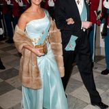 Prinzessin Marie trägt das Kleid aus babyblauem Satin passend zu ihrer Schärpe. Abgerundet wird der Look mit einem Mantel aus Kunstfell.