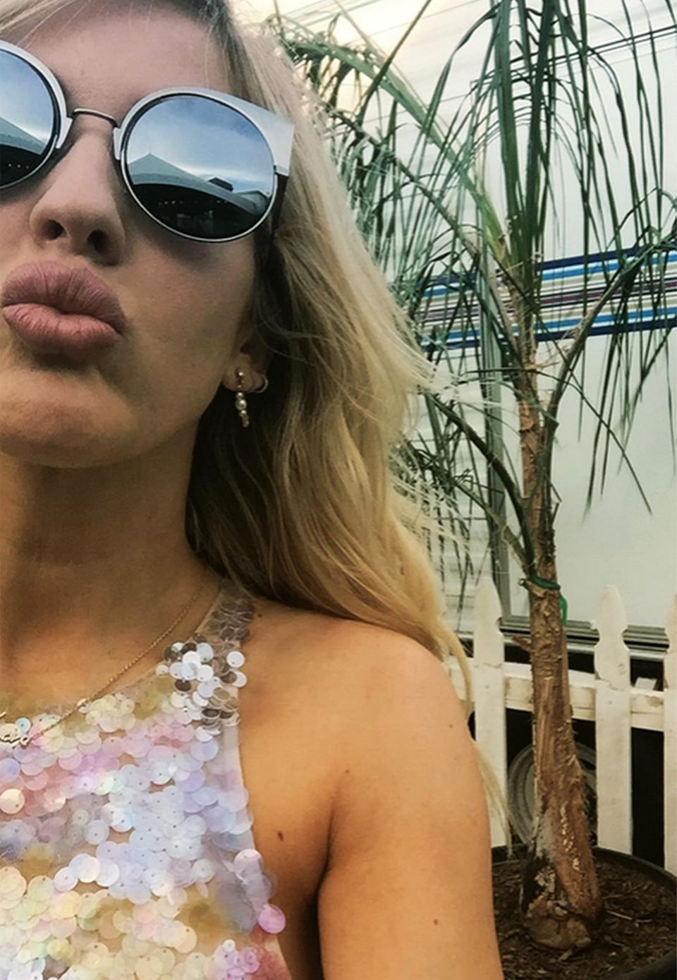 Ellie Goulding gewährt uns aus dem mit Wohnwagen ausgestatteten Künstler-Bereich eine Nahaufnahme auf ihr glamouröses Pailletten-Top und die schicke Fendi-Sonnenbrille.