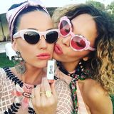 "Coral Cat" nennt Katy Perry (l.) ihr Outfit. Sie trägt eine Sonnenbrille, die ihr Katzenaugen verleiht, sowie einen matten Lippenstift in der Farbe Koralle.